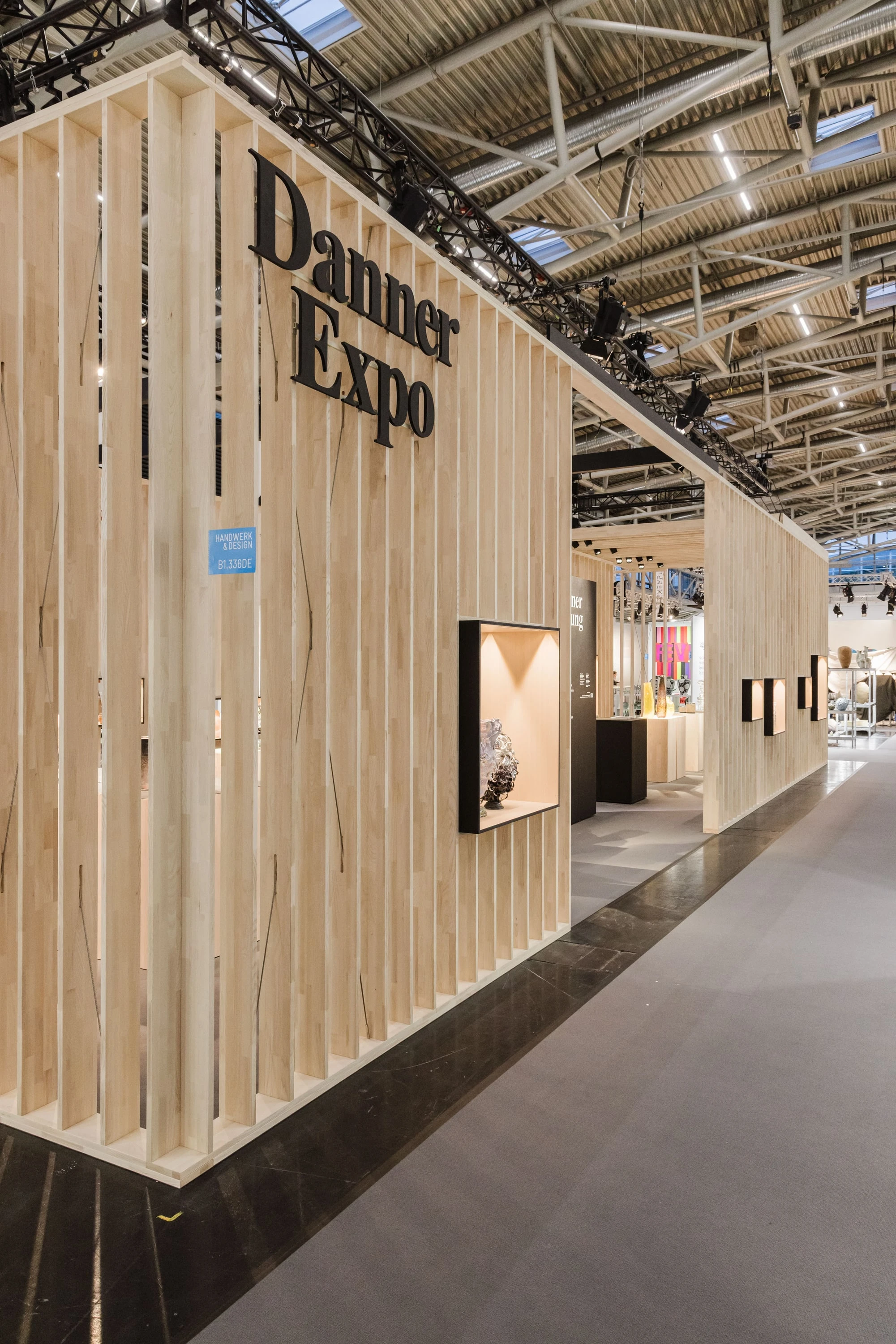 Längsseite des Messestands in Schrägansicht mit dem Schriftzug Danner Expo und Vitrinen in der Lamellenwand.