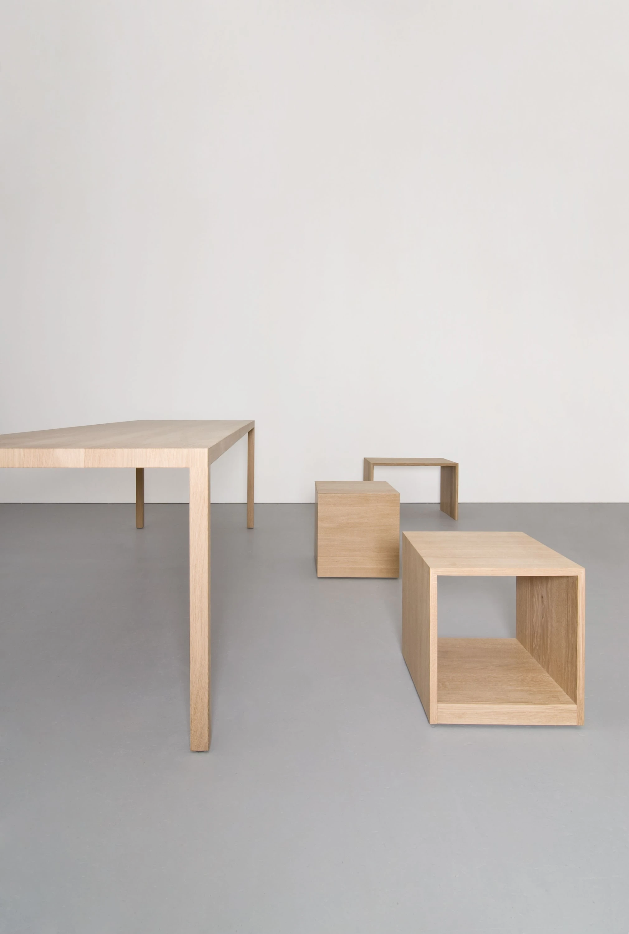 Tisch aus Eiche mit zwei niedrigen Holzkästen als Hocker daneben.