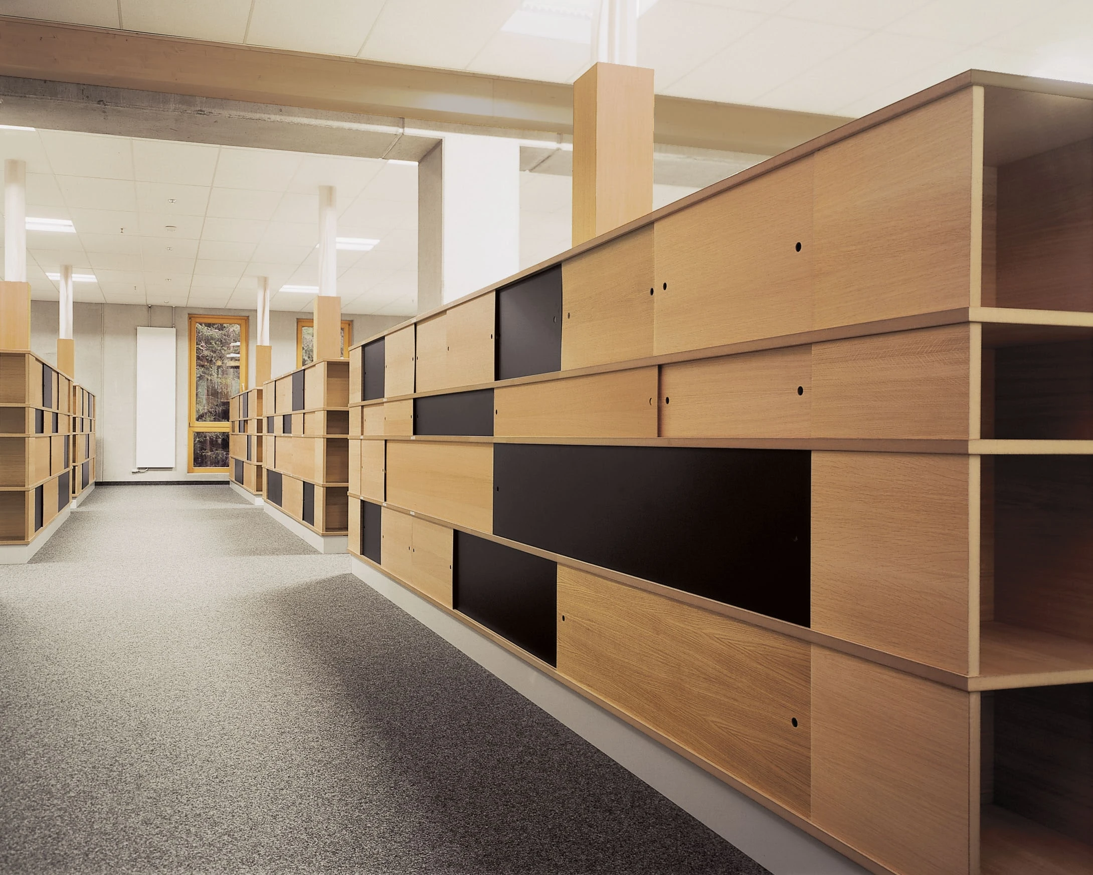 Langer Flur mit Schränken und Highboards aus Eiche mit schwarzen Fronten.