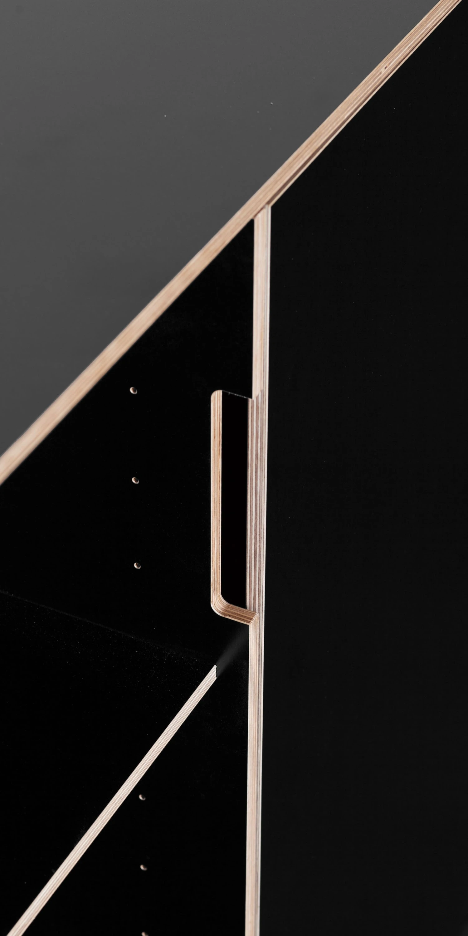 Detail einer schwarzen Front mit Multiplexkante und senkrechtem Griff.