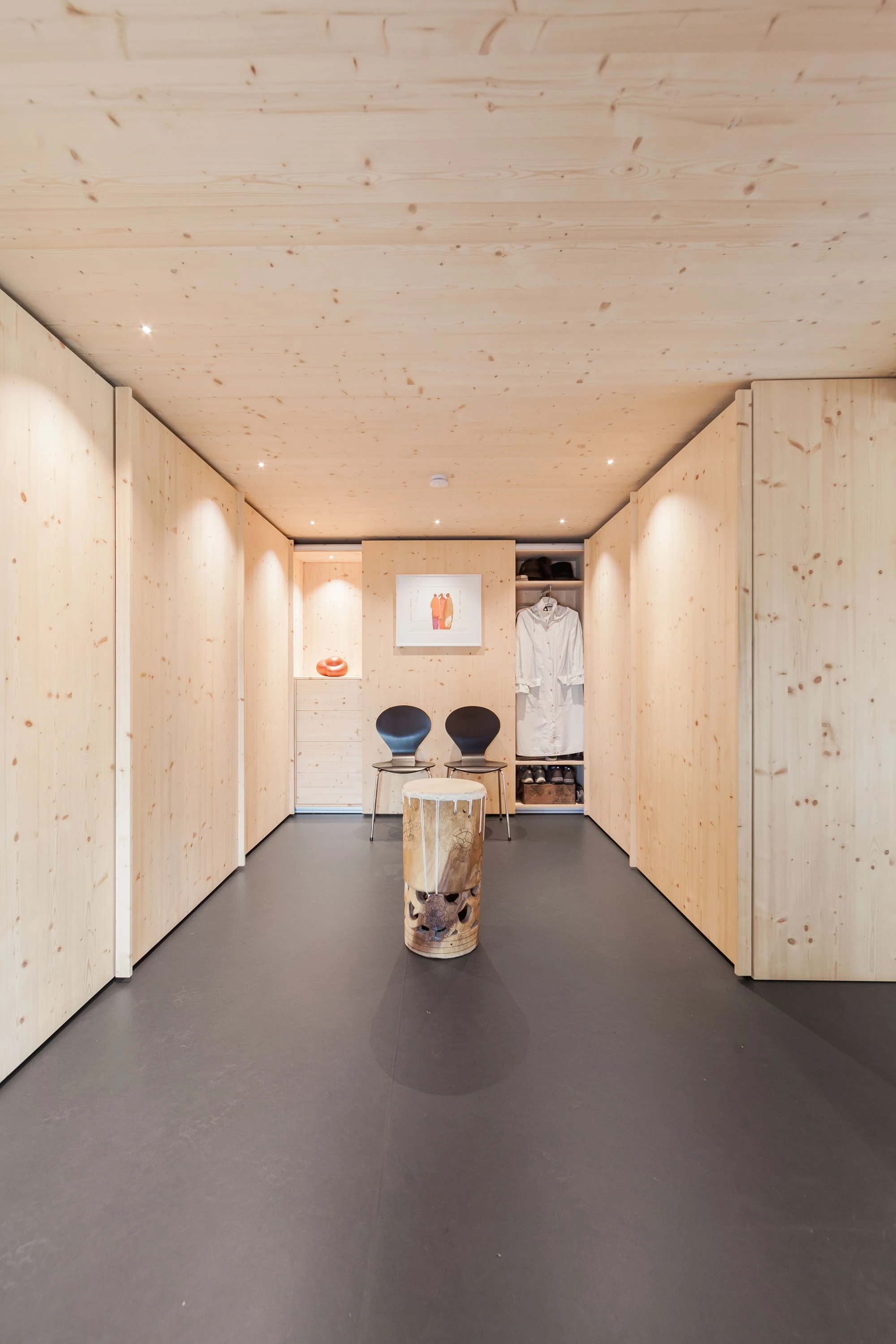 Heller Durchgang mit eingebauten Schränken aus Holz und kleinem Tisch am Ende.