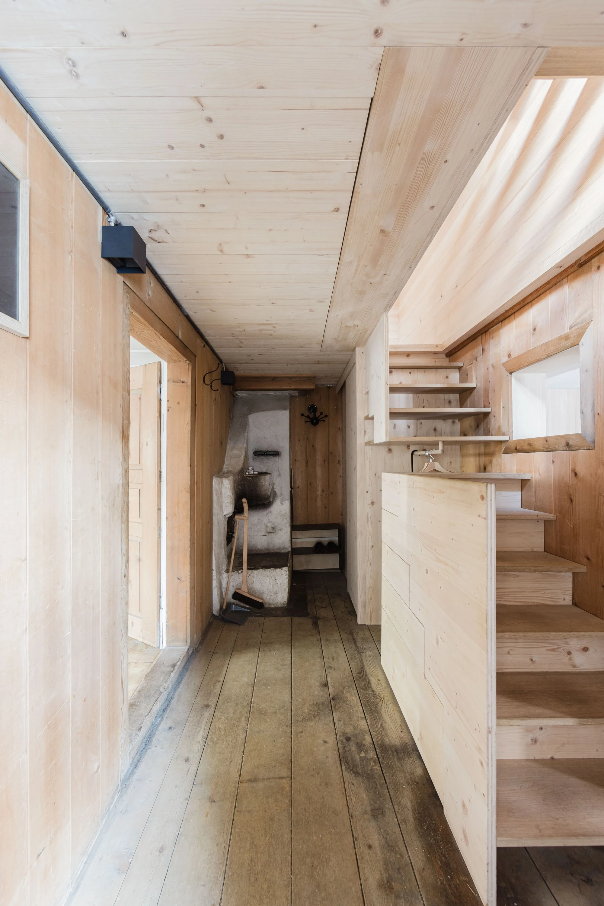 Schmaler Eingangsflur aus Holz mit neuer Treppe.