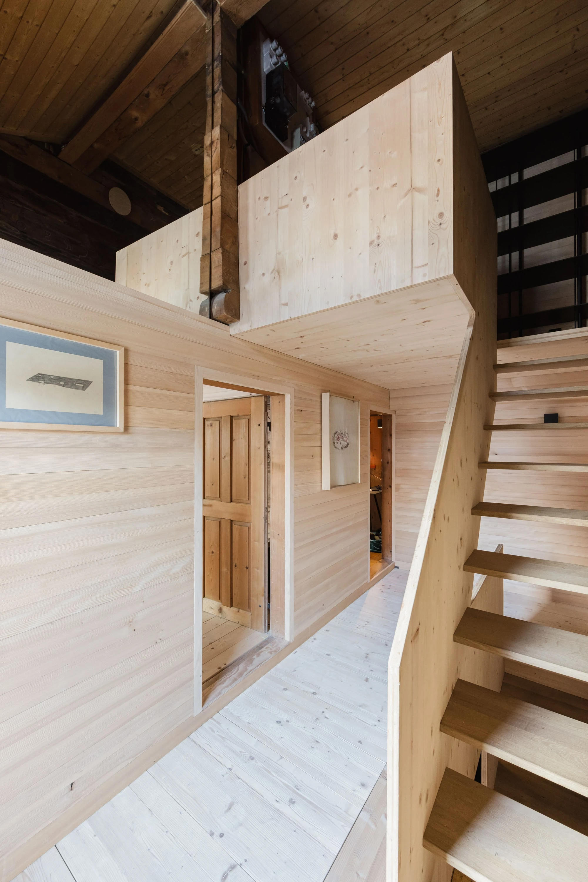 Galerie aus Holz im Dachgeschoss mit Treppe.