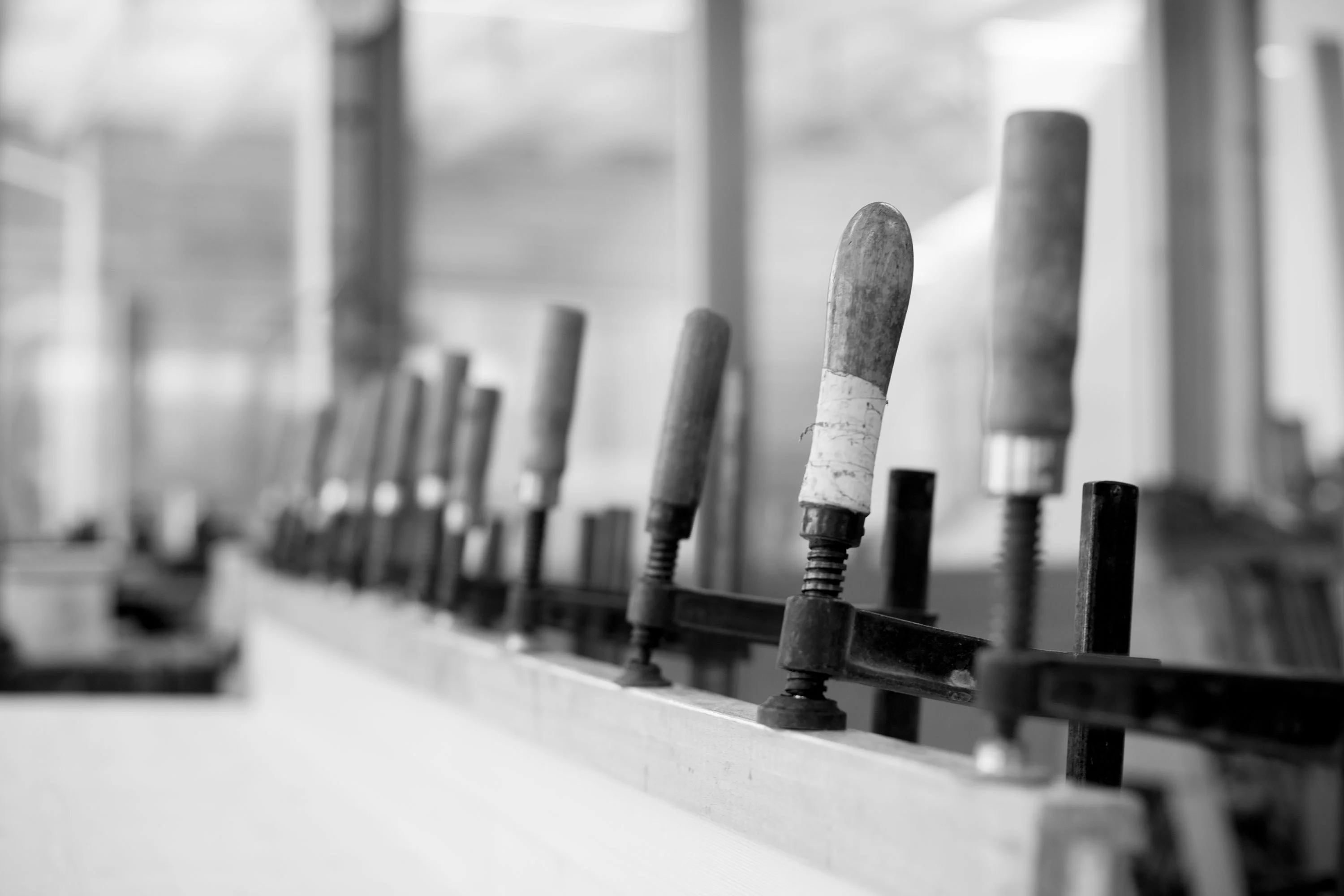 Row of screw clamps on a workbench